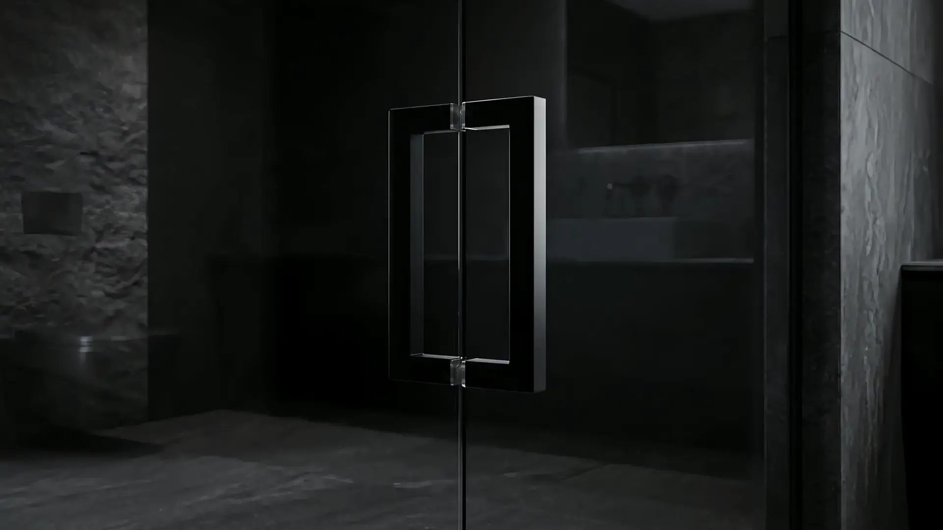 Matte black square pull handle mounted through a dark glass shower door